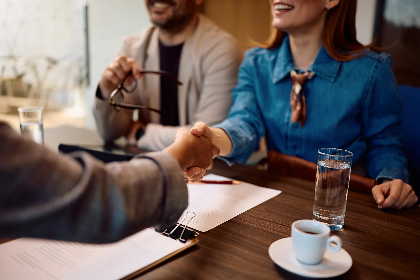 Accreditation consultant shaking hands with a client during a meeting