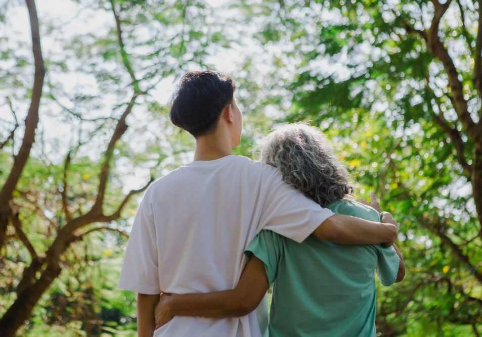 Behavioral health support provider walking outdoors with an older adult